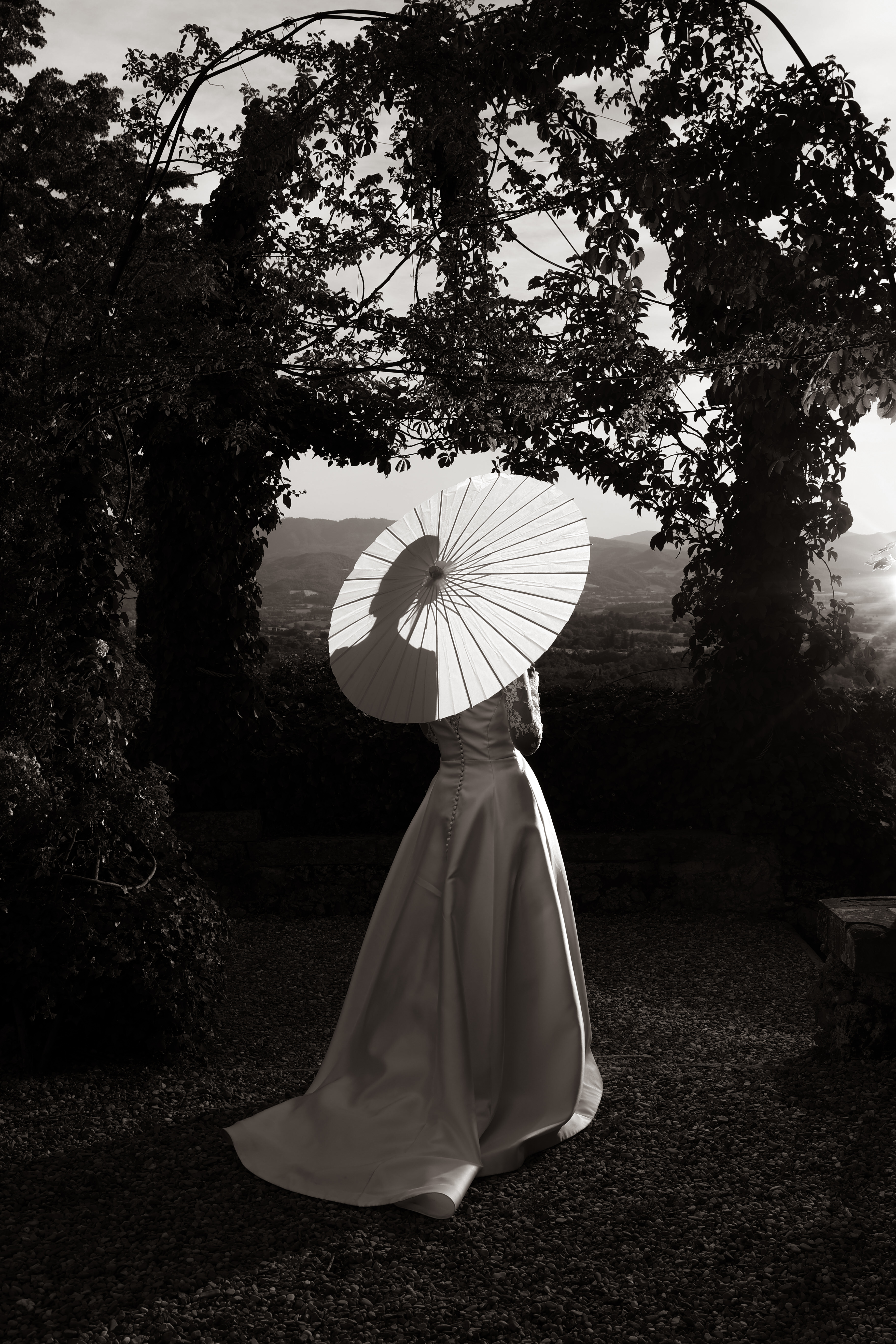 Bride holding a parasol in an Italian garden